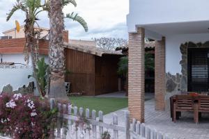 una casa con una valla blanca y una palmera en Villa en Valencia, metro, accesibilidad en La Eliana
