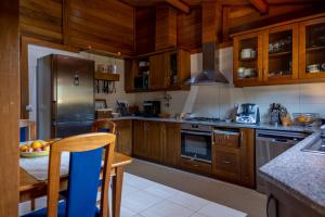 eine Küche mit Holzschränken und Geräten aus Edelstahl in der Unterkunft Refúgio da Perdiz - NATURE'S LUXURY RETREAT (AL) in Juncal