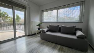 a living room with a couch and a balcony at Nian Apartments - by Avelink in Spáta