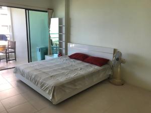 uma cama com duas almofadas vermelhas num quarto em Sea 14 Big Balcony em Pattaya Sul