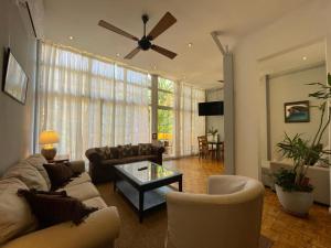 un soggiorno con divano e ventilatore a soffitto di Casa Consell Apartments a Barcellona