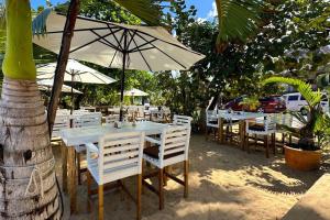 a white table and chairs with an umbrella at La Fenice Beachfront 3 Bedroom With Parking in Las Terrenas