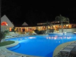 ein großer Pool mit blauem Wasser in der Nacht in der Unterkunft Excepcional Casa en Solanas Resort in Punta del Este