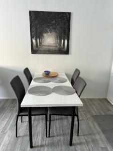 une table blanche avec des chaises et un vase au-dessus dans l'établissement ”Berlin”-home heart of Tornio, à Tornio