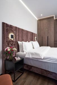 a bedroom with a large bed with a wooden headboard at BonApart Maidan by UHM in Kyiv