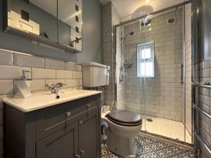 a bathroom with a toilet and a sink and a shower at York Street in Cowes