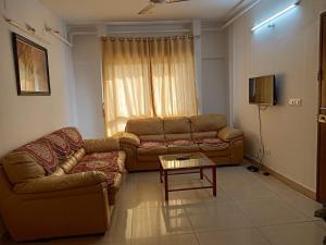 a living room with a couch and a table at 1BHK Service Apartment in Nainital