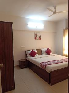 a bedroom with a large bed with red pillows at 1BHK Service Apartment in Nainital