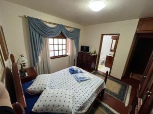 a bedroom with a bed and a window at Apartamento 4 dormitórios no coração de Gramado in Gramado