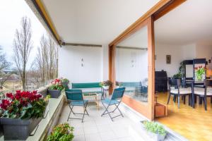 d'un balcon avec des chaises et une table, ainsi que d'une salle à manger. dans l'établissement Tourelle 2 - Spacieux appartement dans le centre de Genève, à Genève