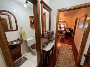 a small bathroom with a sink and a toilet at Apartamento 4 dormitórios no coração de Gramado in Gramado