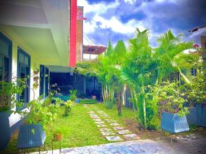 un jardín con palmeras y sillas azules frente a una casa en Sylz Residence Studio 5 - 5 Mins from Labadi & Laboma Beaches, en Accra