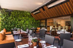 un ristorante con tavoli e sedie e una parete verde di The George a Christchurch