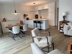 a kitchen and living room with a table and chairs at Logies La Parmentière in De Panne