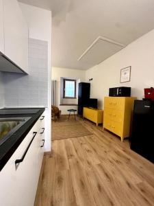 une cuisine vide et un salon avec parquet dans l'établissement Appartamento la Torretta, con giardino!, à Crevoladossola