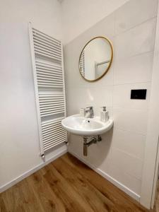 La salle de bains blanche est pourvue d'un lavabo et d'un miroir. dans l'établissement Appartamento la Torretta, con giardino!, à Crevoladossola