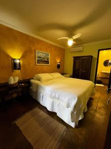 a bedroom with a large white bed in a room at Casario 1915 Pousada in Morretes