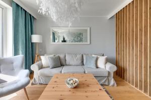 - un salon avec un canapé et une table dans l'établissement Langgarten Apartments by Little Heaven, à Gdańsk