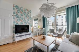 un soggiorno con un divano e una TV di Langgarten Apartments by Little Heaven a Danzica