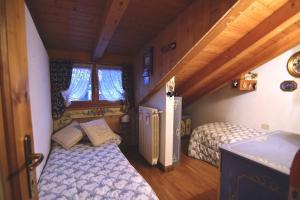 a bedroom with two beds in a room at Cozy attic in the center of San Vito in San Vito di Cadore