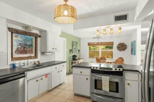 a kitchen with a sink and a stove top oven at Coconut Cove Peaceful Retreat Wpool And Canal in Cocoa Beach
