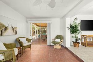 a living room with chairs and a tv on a wall at Coconut Cove Peaceful Retreat Wpool And Canal in Cocoa Beach