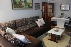 a living room with a brown couch and a table at Tranquilo apartamento en Pola de Siero in Siero
