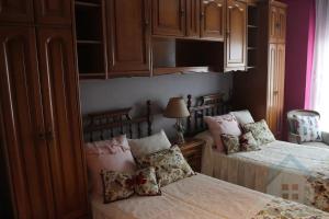 シエロにあるTranquilo apartamento en Pola de Sieroのベッドルーム(ベッド2台、木製キャビネット付)