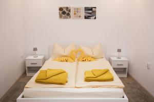 a white bed with yellow blankets and pillows on it at Christian Haus in Sibiu