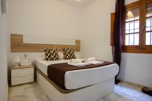 een slaapkamer met een groot bed en 2 handdoeken bij RentalSevilla A los pies de la Alameda de Hércules in Sevilla