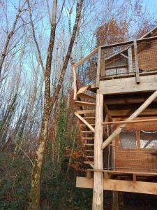 une cabane dans les arbres au milieu des bois dans l'établissement Les hébergements insolites de Quénécan, à Perret