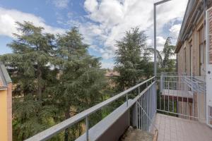 einen Balkon eines Gebäudes mit Bäumen im Hintergrund in der Unterkunft Spacious Apartment x5 with two balconies! in Bologna