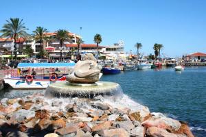 a fountain in the water near a marina with boats at Camping Saint-Cyprien in Saint-Cyprien