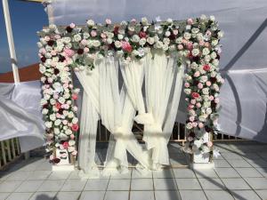 a wedding arch with flowers and white curtains at Csompó Cozy Small One Bedroom Apartment Beach & River property in St Mary