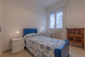 ein Schlafzimmer mit einem blauen Bett und einem Fenster in der Unterkunft Spacious Apartment x5 with two balconies! in Bologna