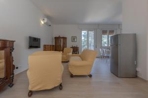 ein Wohnzimmer mit Stühlen und einem Kühlschrank in der Unterkunft Spacious Apartment x5 with two balconies! in Bologna
