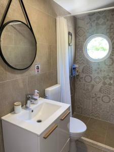 a bathroom with a sink and a toilet and a mirror at Glamping nature Tiny house in Kotor