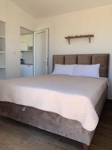 a bedroom with a large bed with white sheets at Glamping nature Tiny house in Kotor