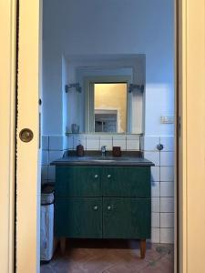 a bathroom with a green sink and a mirror at Casa Bonita in Caserta