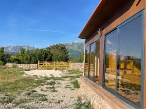 a house with glass windows and a view of the mountains at Glamping nature Tiny house in Kotor