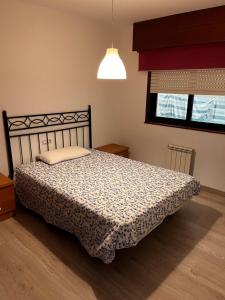 una camera con letto, lampada e finestra di El apartamento de Xavi ad A Coruña