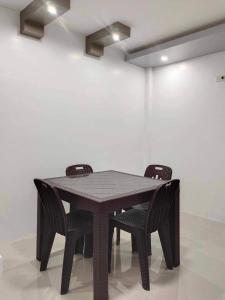 uma mesa de madeira e duas cadeiras num quarto em REGIE Homestay Vigan City em Aggay