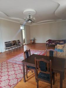 uma sala de estar com uma mesa e cadeiras e um sofá em Nelli guest house em Sayeliavo