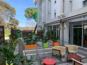 un grupo de sillas y mesas frente a un edificio en ibis Styles Antibes, en Antibes