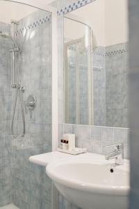La salle de bains est pourvue d'un lavabo et d'une douche avec un miroir. dans l'établissement Villa Telli, à Garde