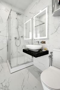 baño blanco con ducha y lavamanos en BonApart Maidan by UHM, en Kiev