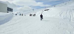 a group of people skiing down a snow covered slope at Hotel Villa in Kutaisi