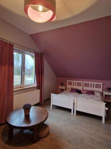a bedroom with two beds and a table and a window at Bite Le Vanda in Miliai