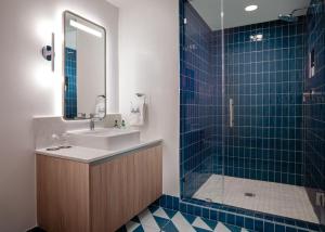 een badkamer met een wastafel en een douche met een spiegel bij Gale Miami Hotel & Residences in Miami