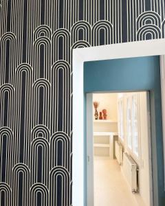 a hallway with a black and white patterned wall at Le FauBourg Suites in Antwerp